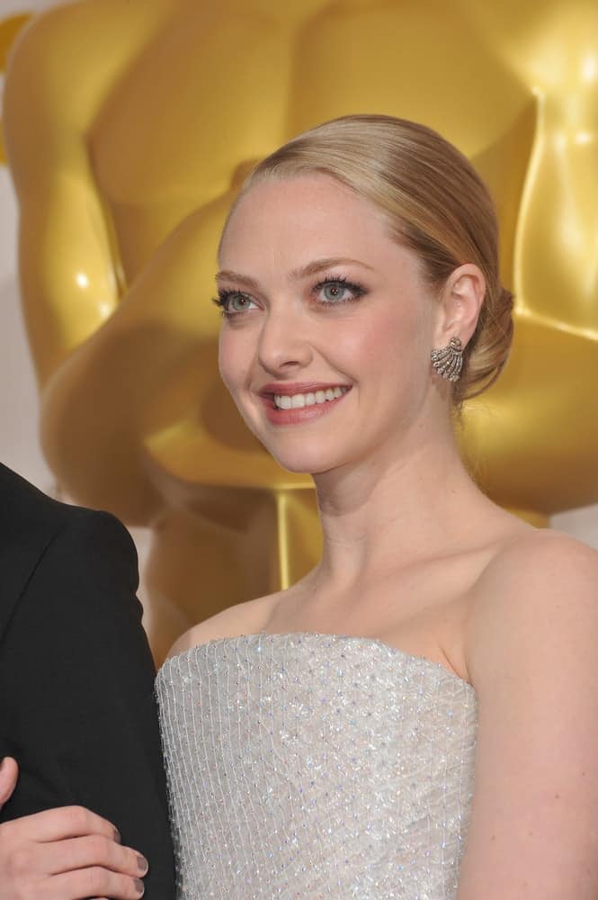 Amanda Seyfried flashed her beautiful smile that complemented her shiny white dress and simple slick low bun hairstyle at the 82nd Academy Awards at the Kodak Theatre, Hollywood on March 7, 2010 in Los Angeles, CA.