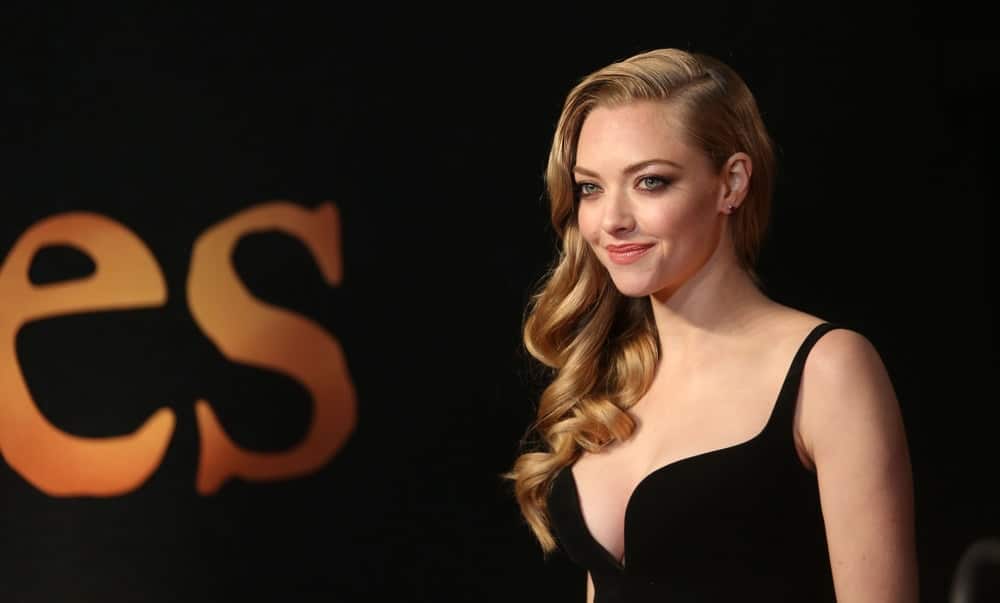 Amanda Seyfried wowed everyone with her sexy and stunning black dress that totally complemented her side-swept loose curly sandy blond hairstyle at the World Premiere of 'Les Miserables' held at the Odeon & Empire Leicester Square, London on December 5, 2012.