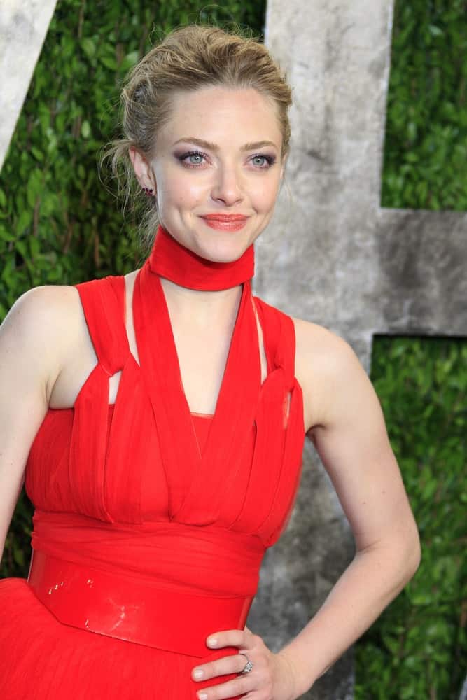 Amanda Seyfried's stylish and fashionable red dress went quite well with her messy and tousled upstyle that has loose tendrils at the Vanity Fair Oscar Party at Sunset Tower on February 24, 2013 in West Hollywood, California.