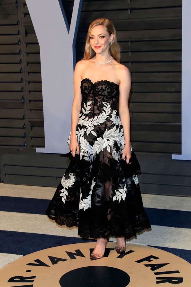 Amanda Seyfried was quite charming in her black and white dress with floral details that paired quite well with her simple straight and loose sandy blond hairstyle on her back at the 24th Vanity Fair Oscar After-Party on March 4, 2018 in Beverly Hills, CA.