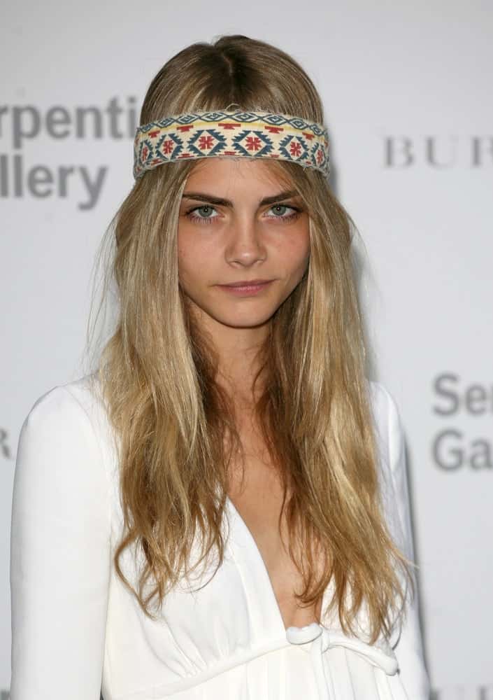 Cara Delevingne's simple white dress and long, loose tousled sandy blond hairstyle were complemented by a stylish patterned headband at the Burberry Serpentine Summer Party, at the Serpentine Gallery in London on June 28, 2011.