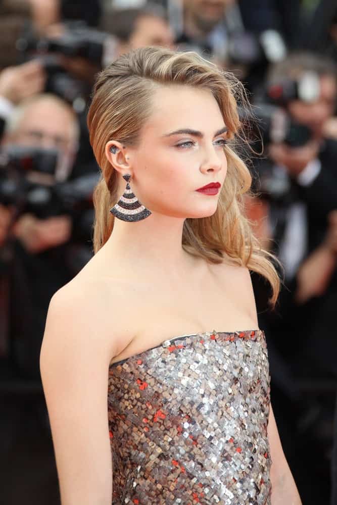 Cara Delevingne partnered her silver sequined dress with a pinned side-swept hairstyle that has highlights and side-swept wavy bangs at the 'The Search' premiere during the 67th Annual Cannes Film Festival on May 21, 2014 in Cannes, France.