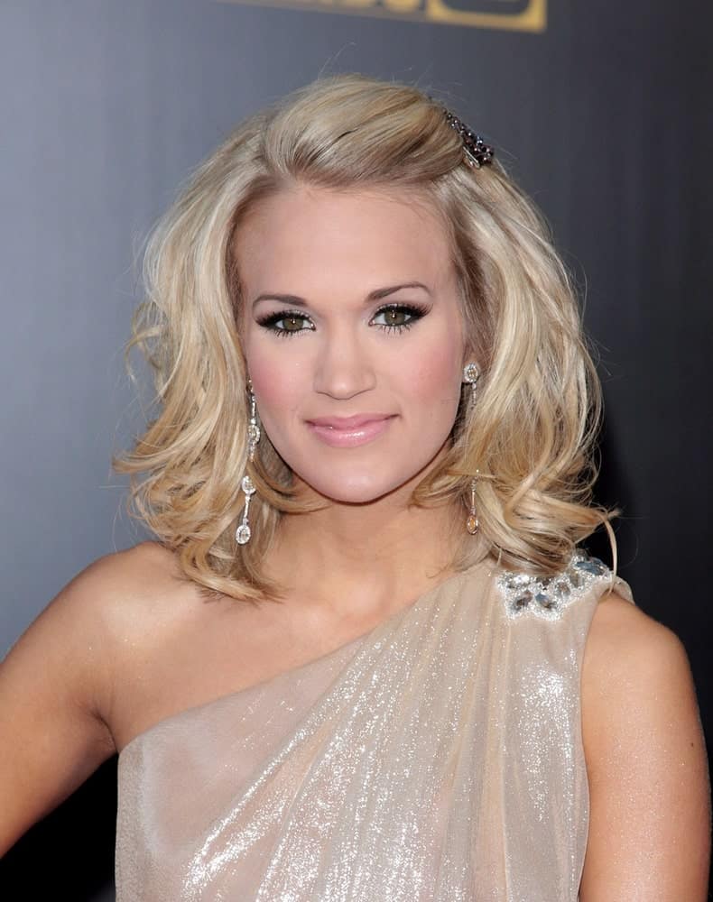 Carrie Underwood looks like a goddess in a nude halter dress along with her medium-length waves that she pinned on one side during the 2009 American Music Awards on November 22, 2009.