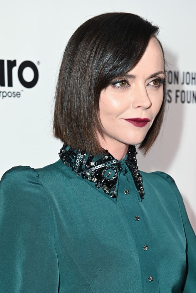 Christina Ricci was at the red carpet of Elton John AIDS Foundation Party on February 09, 2020 in Los Angeles, California. She was seen in an elegant green dress that she paired with a straight raven chin-length hairstyle with side-swept bangs.