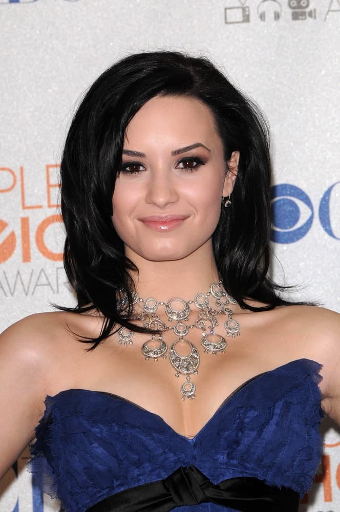 Demi Lovato's lovely blue strapless dress paired quite well with her raven shoulder-length hairstyle that has layers and a side-swept bangs at the 2010 People's Choice Awards Press Room, Nokia Theater L.A. Live in Los Angeles, CA on January 6, 2010.