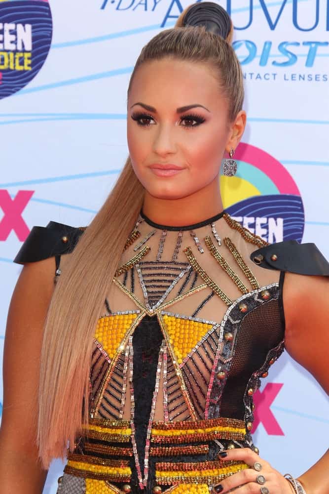 Demi Lovato's colorful sequined dress and confident smile was quite a pair with her long and straight platinum blond hairstyle that was swept up for a slick high ponytail at the 2012 Teen Choice Awards at Gibson Ampitheatre on July 22, 2012 in Los Angeles, CA.