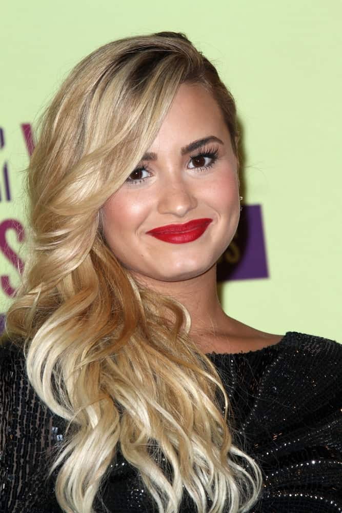 Demi Lovato's black sequined dress complemented her bright blond curls side-swept to her shoulder with a slight tousle and side-swept bangs at the 2012 Video Music Awards Press Room, Staples Center in Los Angeles, CA on September 6, 2012.