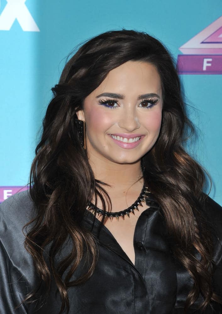 Demi Lovato was at the press conference for the season finale of Fox's "The X Factor" at CBS Televison City in Los Angeles on December 17, 2012. She wore a black satin outfit that matched well with her long and wavy raven hair with layers and highlights.