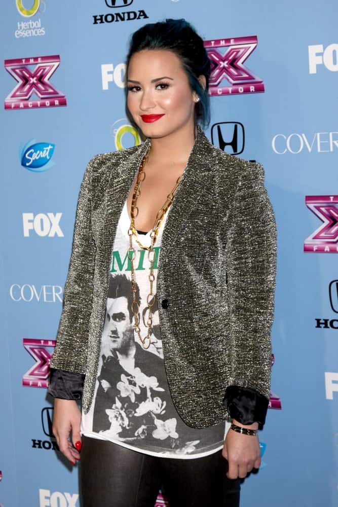 Demi Lovato's smart casual outfit paired quite well with her blue-toned dark hairstyle that was swept up for a bun hairstyle that has loose tendrils on the side at the 2013 "X Factor" Top 12 Party at the SLS Hotel on November 4, 2013 in Beverly Hills, CA.