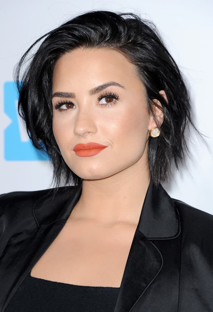Demi Lovato's short raven hair was tossed up for a tousled side-swept finish to match with her black outfit at the WE Day California held at the Forum in Inglewood, USA on April 7, 2016.