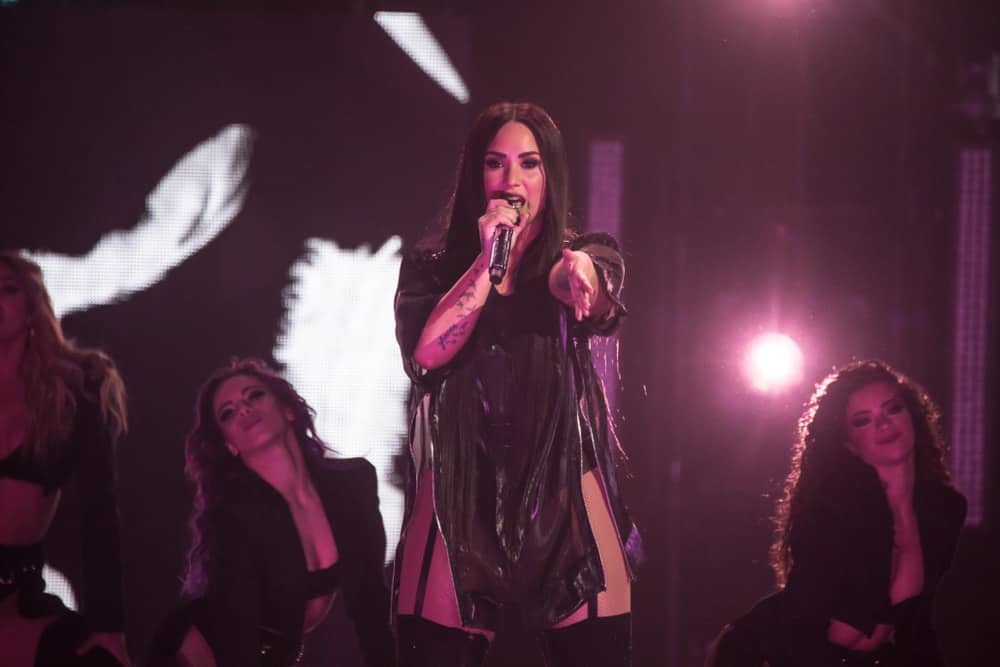 On March 13, 2018, Demi Lovato performed at Little Caesars Arena on her Tell Me You Love Me world tour in Detroit, Miami. She wore a sexy black outfit that she paired with her long and straight raven hairstyle that has a slight tousled finish.