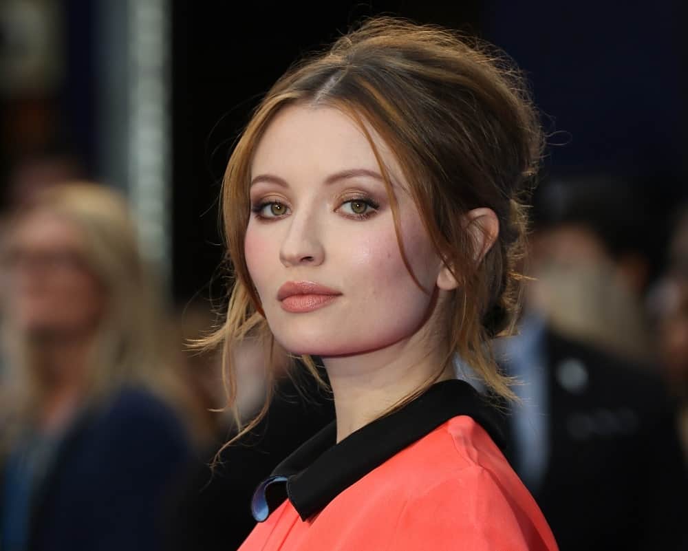 Emily Browning attended the Legend UK film premiere on September 3, 2015, in London. She wore an elegant dress to pair with her messy brunette bun hairstyle that has long side-bangs and tendrils.