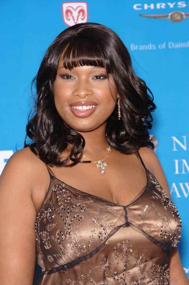 Jennifer Hudson was at the 37th Annual NAACP Image Awards at the Shrine Auditorium in Los Angeles on February 25, 2006. She wore a golden dress that she paired with a tousled curly shoulder-length hairstyle that has blunt bangs.
