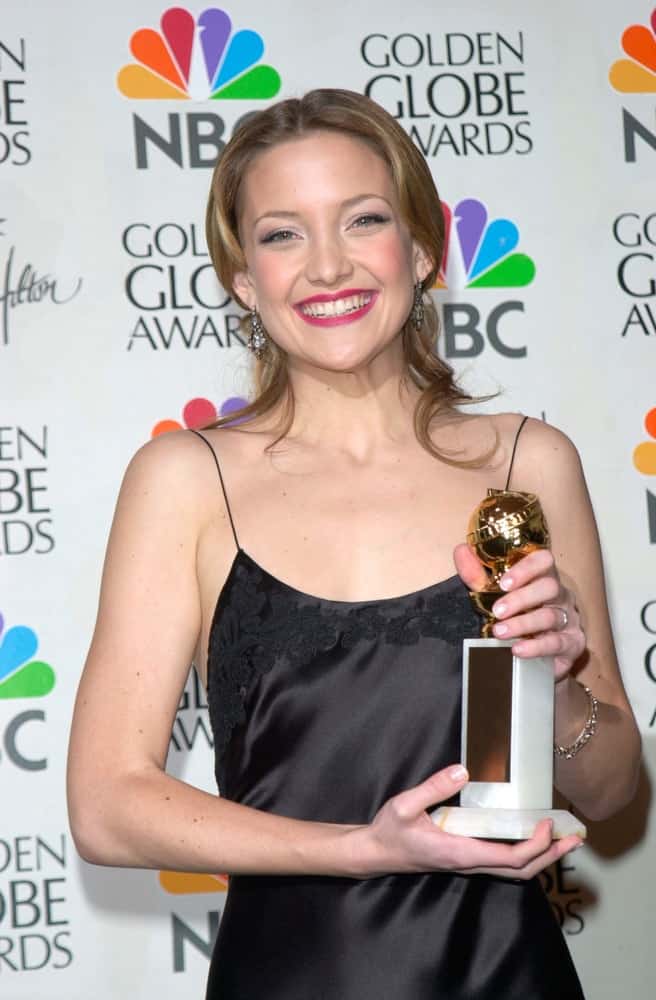 Actress Kate Hudson held her hard-earned trophy at the 2001 Golden Globe Awards at the Beverly Hilton Hotel on January 21, 2001. She came wearing a simple black silk dress that she paired with a half-up hairstyle with curls at the tips and a brownich tone.
