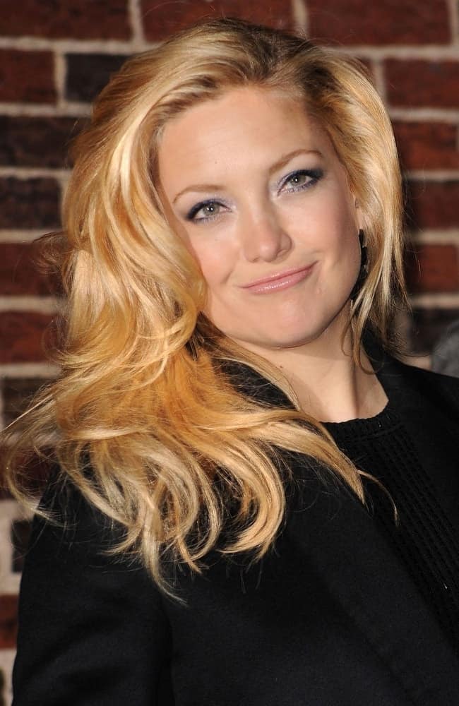 Kate Hudson was at a talk show appearance for The Late Show with David Letterman at the Ed Sullivan Theater in New York, NY on December 14, 2009. She wore a black smart casual jacket with her side-swept and tousled wavy blond layers.