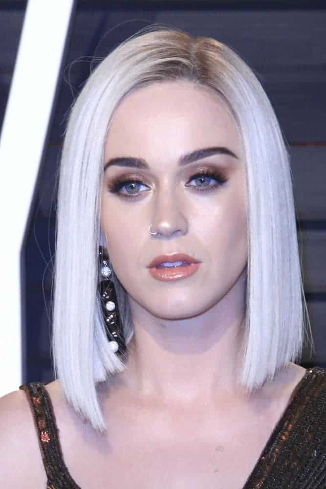Katy Perry cozies up in a bronze beaded gown and she sported a sleek blonde bob hairstyle to contrast her outfit for this 2017 Vanity Fair Oscar Party at the Wallis Annenberg Center on February 26, 2017.