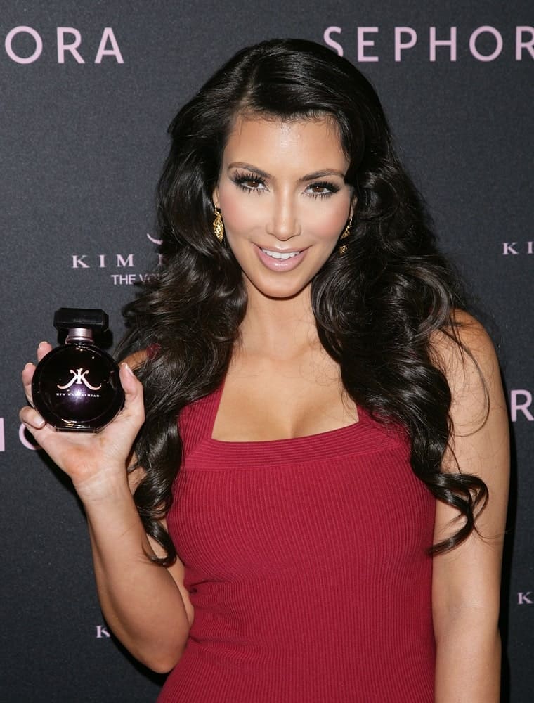 Kim Kardashian at an in-store appearance for Kim Kardashian Fragrance Launch on February 4, 2010, flaunting her voluminous side-parted waves paired with a red dress.
