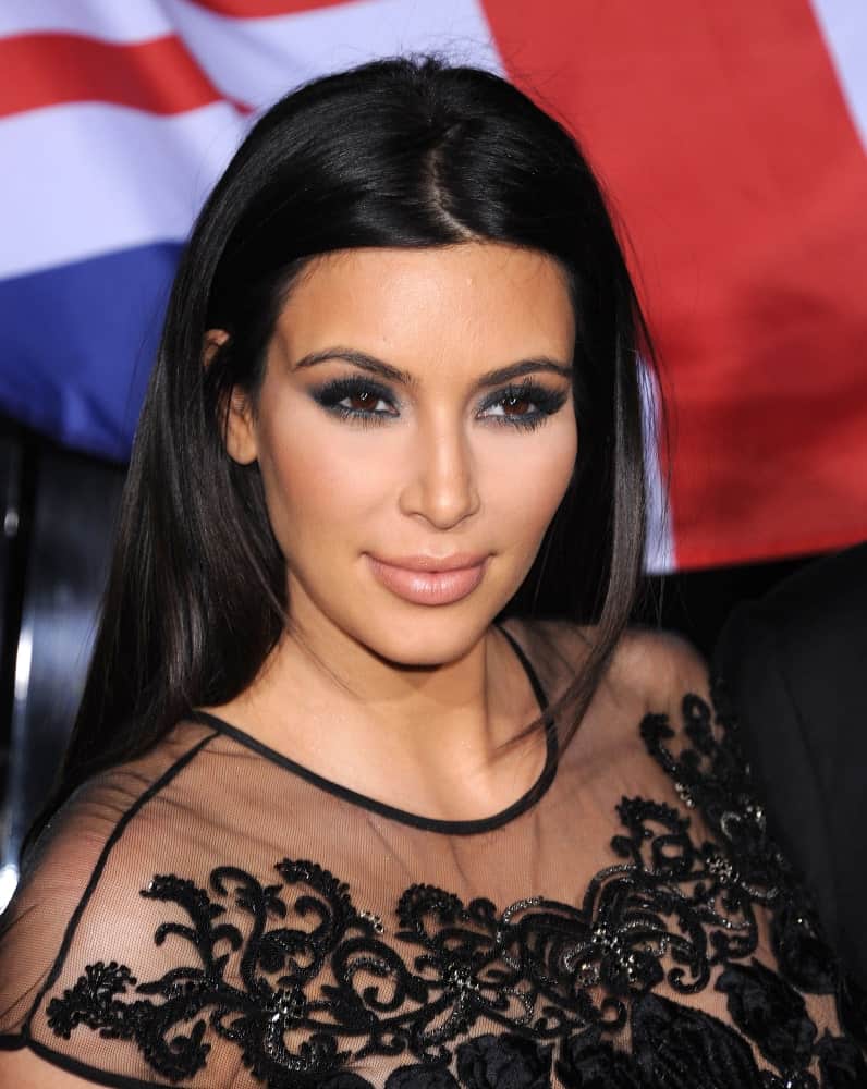 Kim Kardashian pulled off her usual center-parted loose hairstyle that's paired with a sophisticated black lace gown at the Topshop Topman Store Opening Party on February 13, 2013.