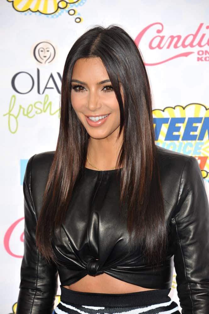 Kim Kardashian opted for a long layered hairstyle with a middle parting at the 2014 Teen Choice Awards at the Shrine Auditorium held on August 10, 2014. 
