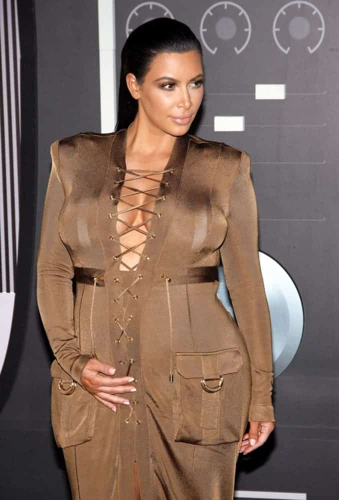 Kim Kardashian showed off her baby bump in a camo colored full-length dress and she was absolutely glowing with this sexy long slicked back hairstyle during the 2015 MTV Video Music awards.