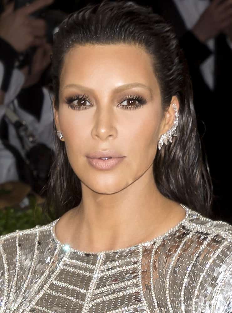 Kim Kardashian dazzled in a silver metallic long sleeve gown and gave a fresh vibe with her slicked back wet hair look as she attends the 2016 MET gala.