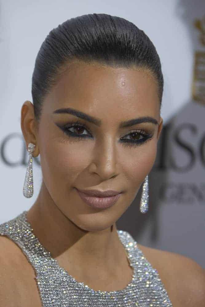 Kim Kardashian displays her signature curves in a sparkling silver chainmail gown and she looks flawless with her raven locks pinned back in a tight bun as she attends the annual 69th Cannes Film Festival.