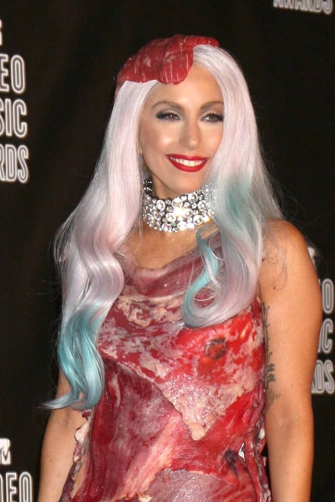 Lady Gaga was at the 2010 MTV Video Music Awards at Nokia - LA Live on September 12, 2010 in Los Angeles, CA. This was one of her controversial looks. She wore a dress and headdress made of raw red meat that she paired with a long wavy platinum blond hair with blue dyed tips.