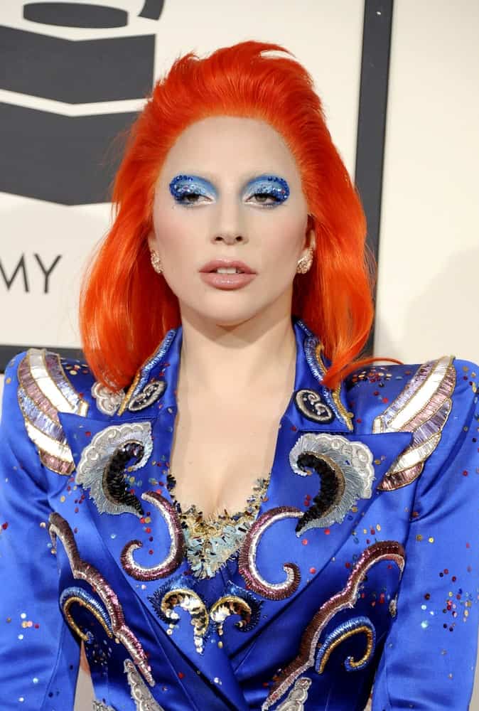 Lady Gaga wore a red orange dyed hairstyle that contrasts her blue marching band jacket at the 58th GRAMMY Awards held at the Staples Center in Los Angeles on February 15, 2016.