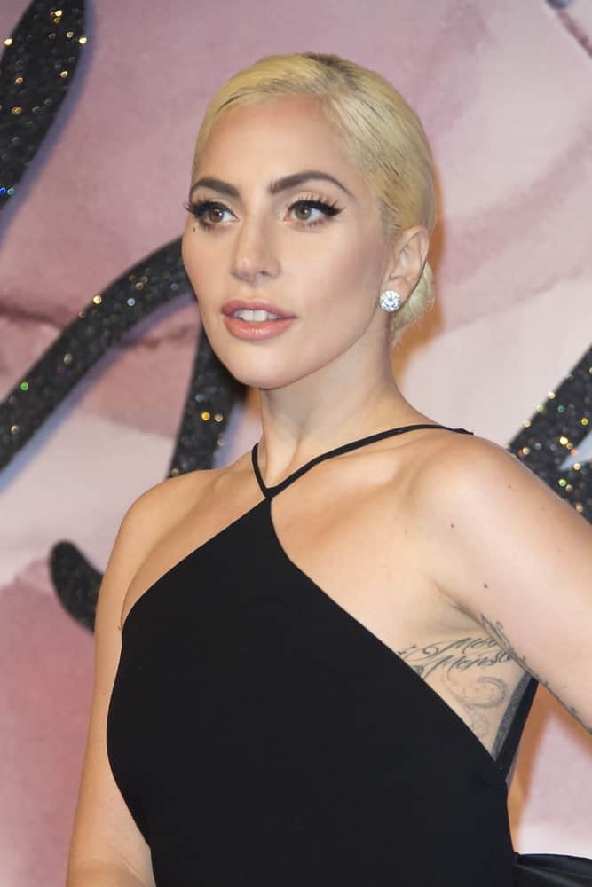 On December 5, 2016, Lady Gaga attended The Fashion Awards 2016 in London, United Kingdom. She came with a simple yet classy black dress that emphasizes her elegant neckline together with her slick blond low bun hairstyle.