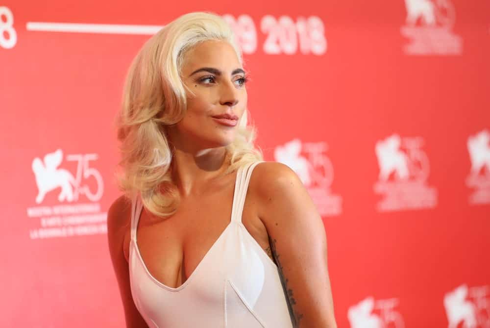 Lady Gaga attended the 'A Star Is Born' photocall during the 75th Venice Film Festival at Sala Casino on August 31, 2018 in Venice, Italy. She was lovely in her simple white dress and wavy white blond layers that complements her simple make-up.