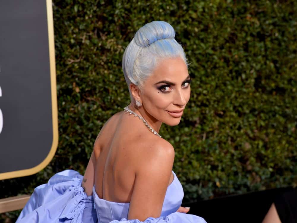On January 06, 2019, Lady Gaga attended the 2019 Golden Globe Awards at the Beverly Hilton Hotel. She was a picture of sophistication in her classy blue gown that matches well with her top knot hairstyle on her platinum blond hair with blue highlights.