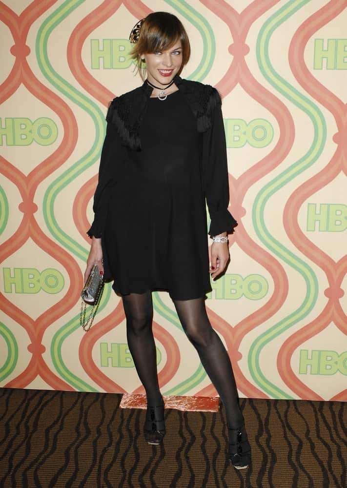 Milla Jovovich was at the HBO Golden Globe After Party, CIRCA 55 Restaurant in Beverly Hills, CA on January 15, 2007. Her black dress paired with a messy bun hairstyle with bangs.