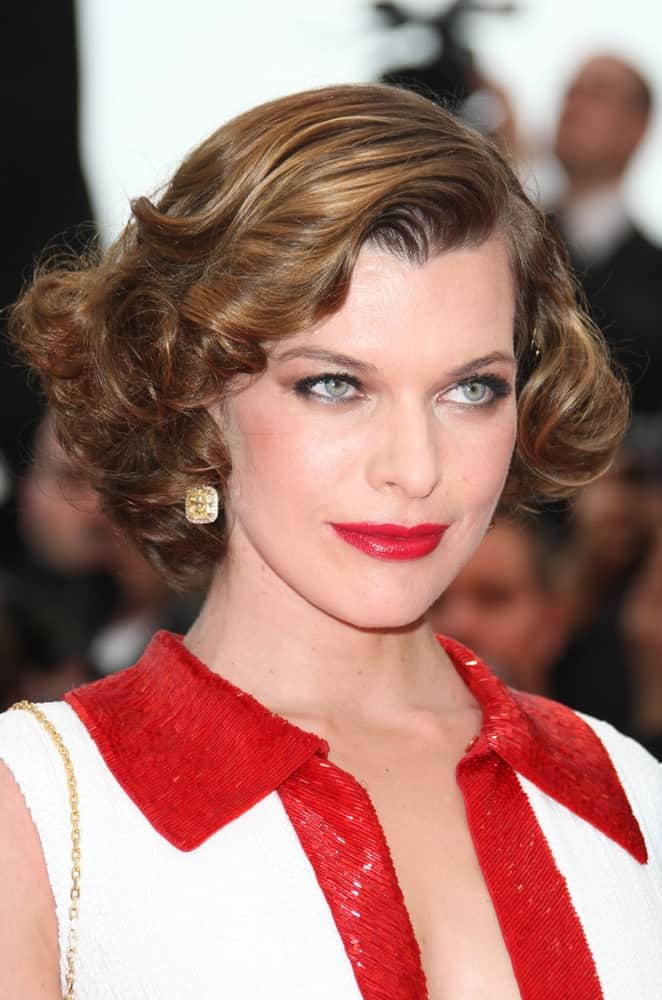 Milla Jovovich was at the 'La Conquete' Premiere, 2011 Cannes Film Festival on May 18,2011. Her red lips were a perfect match for her dress and chin-length curly hairstyle with side-swept bangs,