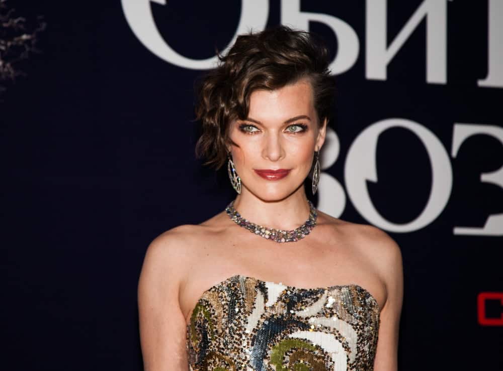 Milla Jovovich attended the Premiere of the movie "Resident Evil" on September 6, 2012, at the OCTOBER CINEMA in Moscow, Russia. She was seen wearing a strapless golden dress to match her lovely side-swept, tousled and wavy chin-length brunette hairstyle.