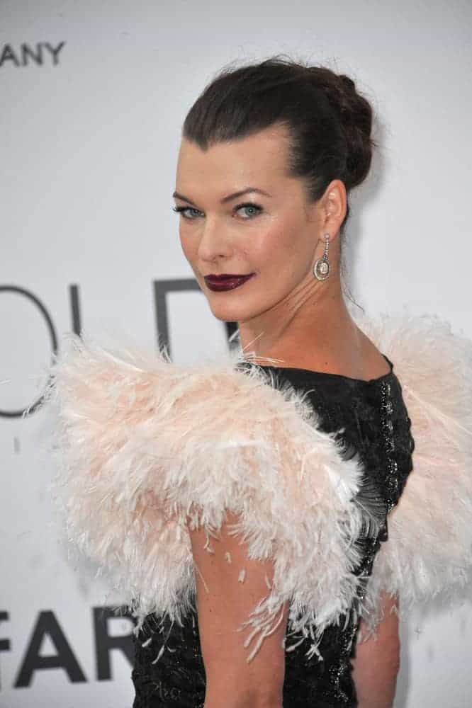 On May 22, 2014, Milla Jovovich was at the 21st annual amfAR Cinema Against AIDS Gala at the Hotel du Cap d’Antibes. She was stunning in her ruffled dress, dark lips, and slicked back raven bun hairstyle.