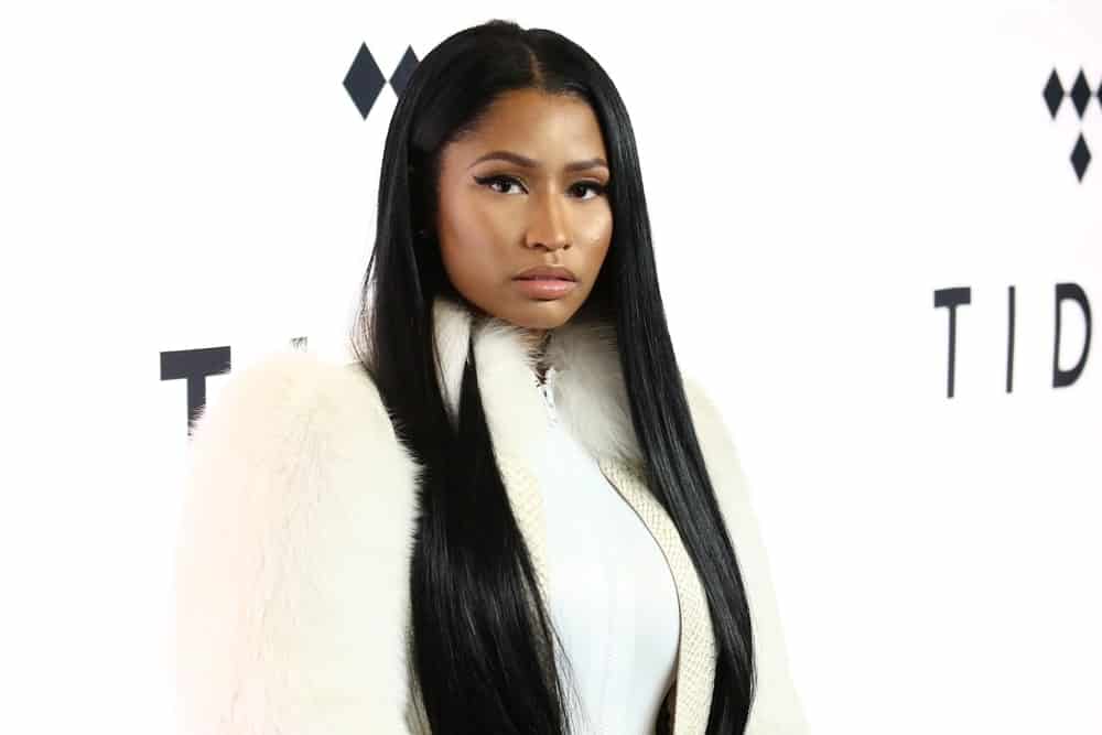 Nicki Minaj went with a simple make-up and wore an all-white outfit that emphasized her center-parted long and straight raven hairstyle tucked behind her ear at the TIDAL X: 1015 concert at the Barclays Center on October 15, 2016, in New York.