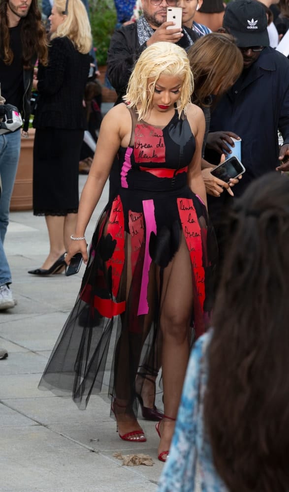 On September 11, 2018, Nicki Minaj attended the runway for Oscar De La Renta during New York Fashion Week Spring/Summer 2019 at Spring Studios Terrace. She was seen wearing a fashion forward red and black dress to match her shoulder-length blond hairstyle with a tousled wet-look finish.