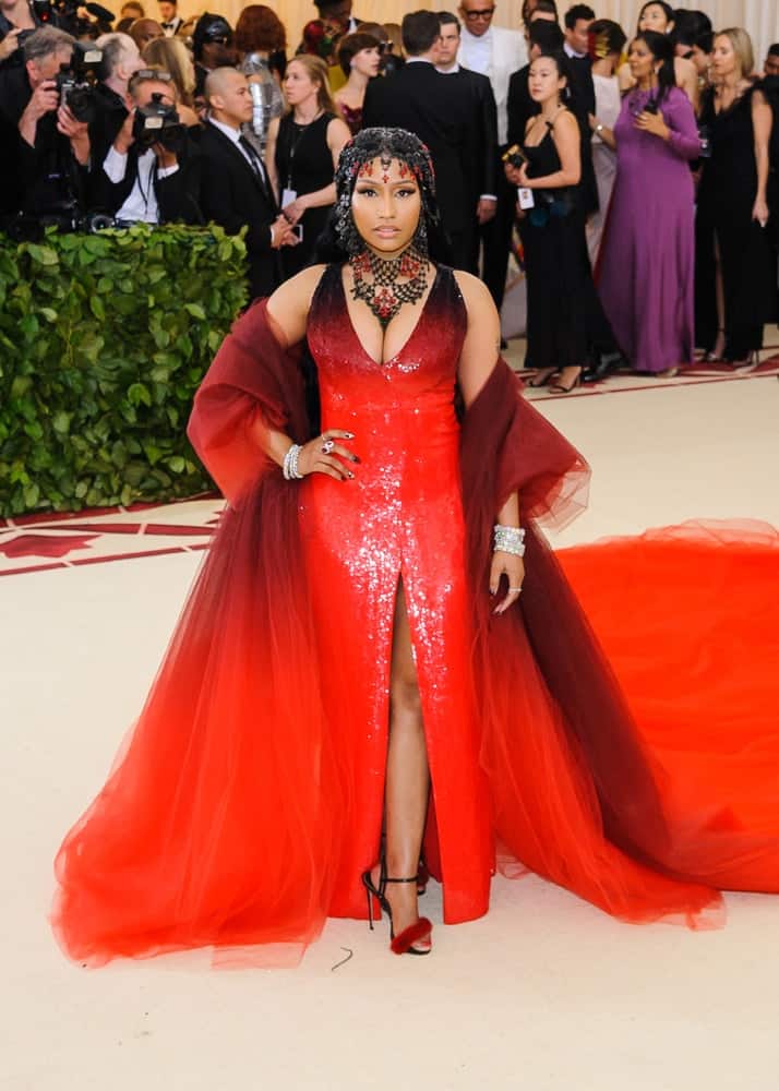 Nicki Minaj attended the 2018 Metropolitan Museum of Art Costume Institute Benefit Gala on May 7, 2018 at the Metropolitan Museum of Art in New York, New York. She wore a lovely red and black dress to go with her straight and long black hair incorporated with gemstones.