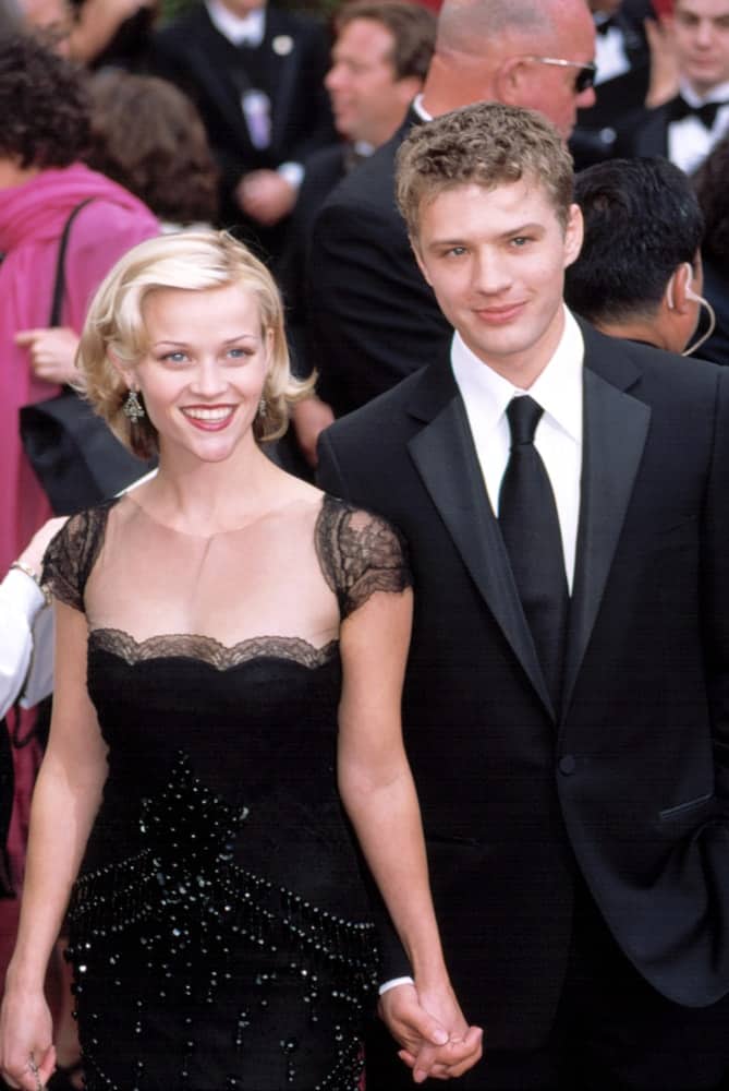 Reese Witherspoon and Ryan Phillippe were at the Academy Awards on March 24, 2002 in Los Angeles, California. Witherspoon wore a lovely and elegant black dress to go with her short layered blond hairstyle that has curls at the tips and side-swept bangs.