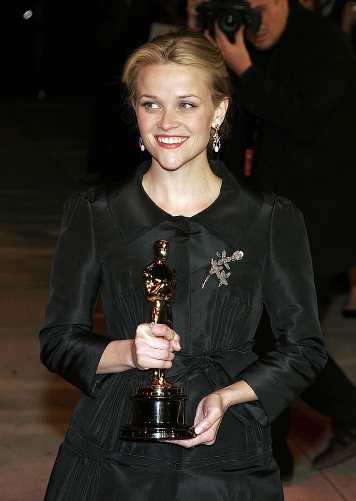 Reese Witherspoon was at the Vanity Fair Oscar Party held at the Mortons Restaurant in West Hollywood, Los Angeles, CA on March 05, 2006. She came holding her trophy while wearing a lovely black dress with her hair swept up into a blond bun hairstyle.