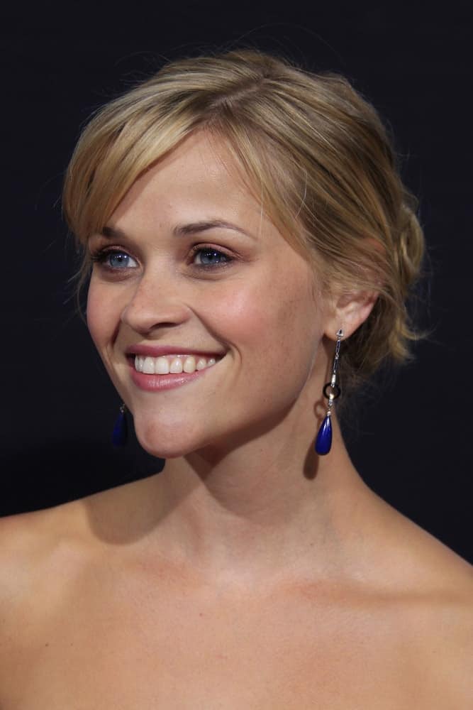 Reese Witherspoon flashed her iconic and brilliant smile that she paired with a couple of charming earrings and a messy bun hairstyle with side-swept bangs at the Rendition Premiere in Beverly Hills, California on October 10, 2007.