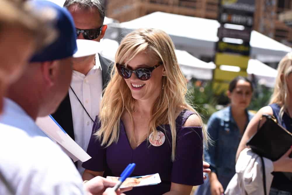 Reese Witherspoon signed some autographs at the Goldie Hawn & Kurt Russell Hollywood walk of fame Star receiving ceremony at the Hollywood Blvd on May 4, 2017 in Los Angeles, CA. She came wearing a purple dress to pair with her tousled and layered loose blond hair with bangs.