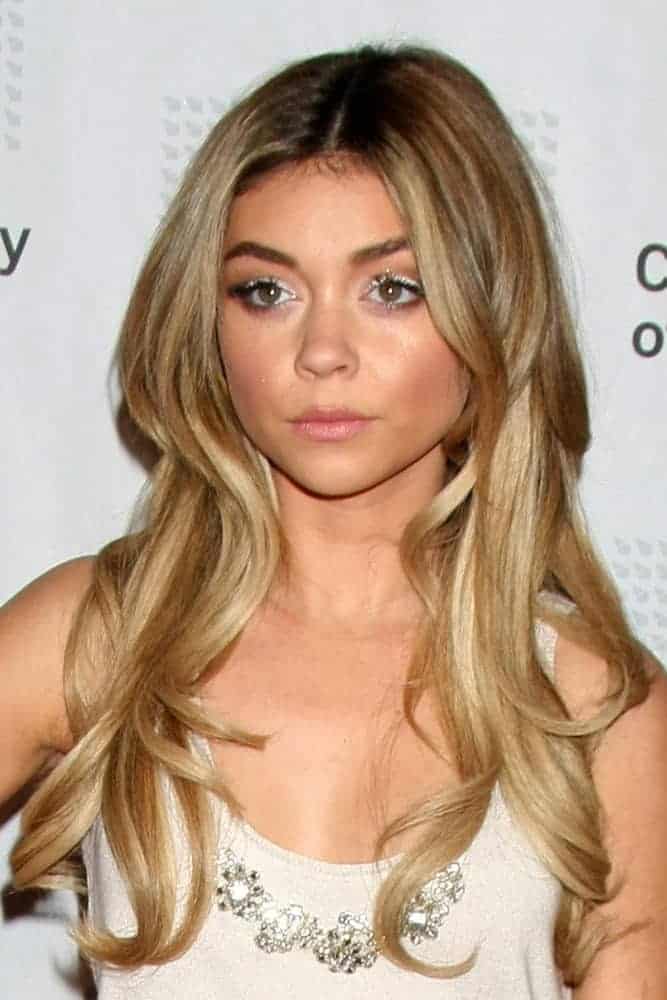 Sarah Hyland was at the American Casting Society presents 30th Artios Awards at a Beverly Hilton Hotel on January 22, 2015, in Beverly Hills, CA. She paired her white dress with a long and wavy sandy blond hairstyle with layers loose on her shoulders.