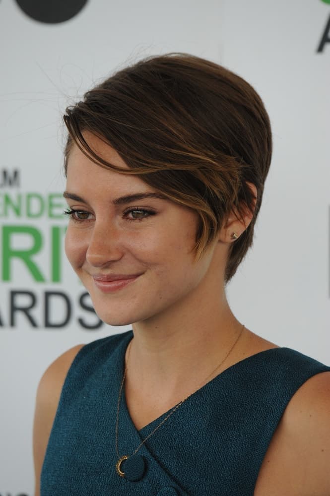 On March 1, 2014, Shailene Woodley attended the 2014 Film Independent Spirit Awards on the beach in Santa Monica, CA. She paired her green outfit with a highlighted brunette pixie hairstyle with long side-swept bangs.