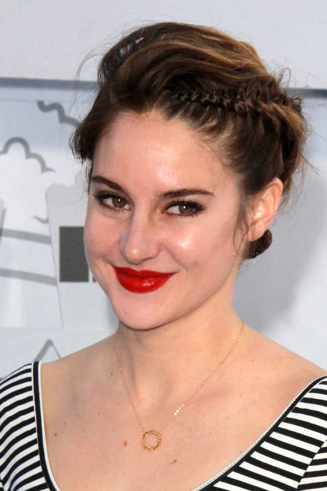 Shailene Woodley was at the MTV Movie Awards 2015 at the Nokia Theater on April 11, 2015 in Los Angeles, CA. She paired her red lips with a tousled brunette bun hairstyle with braids.