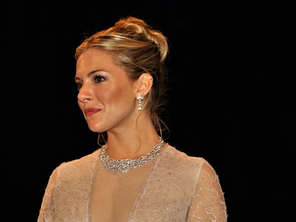 Sienna Miller shines in a glam updo that's paired with silver earrings and a collar necklace during UNESCO-Gala in 2010 at Dusseldorf, Germany.