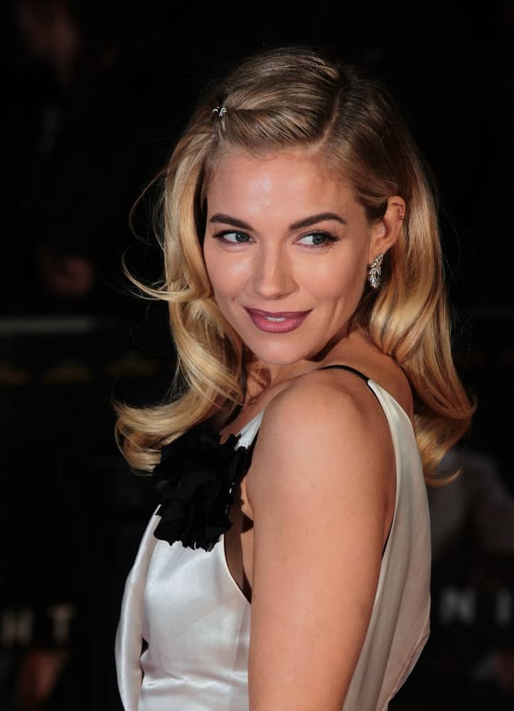 Sienna Miller looks sensational wearing her silky monochrome dress and her blonde waves were styled in a loose side-part with one side pinned up as she attends the Live By Night European film premiere on January 11, 2017.
