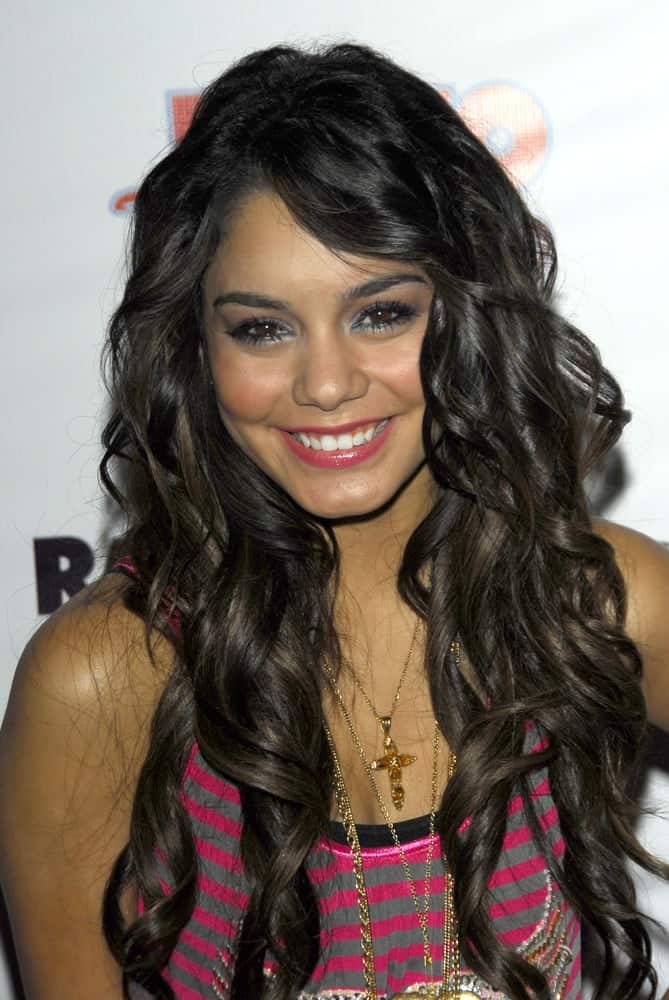 Vanessa Anne Hudgens wore a striped pink casual top with her long and loose tousled curly raven hairstyle with long side-swept bangs at the Radio Disney Totally 10 Birthday Concert on July 22, 2006 at Anaheim Pond in Anaheim, CA.