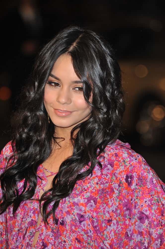 On March 2, 2009, Vanessa Hudgens attended the US premiere of "Watchmen" at Grauman's Chinese Theatre, Hollywood. Her colorful floral outfit paired perfectly well with her long and loose wavy raven hairstyle with layered bangs.