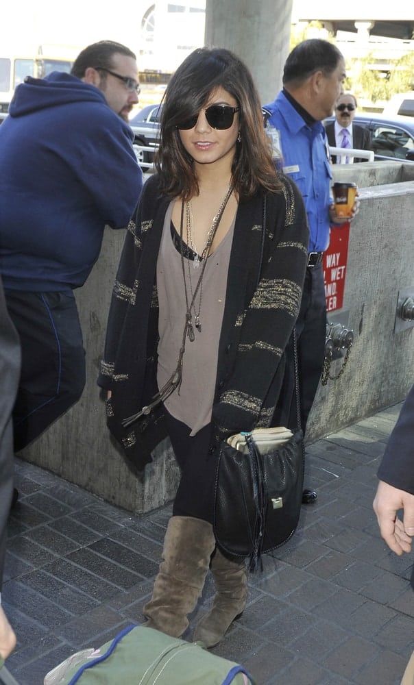 Actress Vanessa Hudgens was seen at the LAX airport on March 28, 2011 in Los Angeles, California. She was charming in her casual clothes that went pretty well with her loose and tousled highlighted shoulder-length hairstyle with long side-swept bangs.